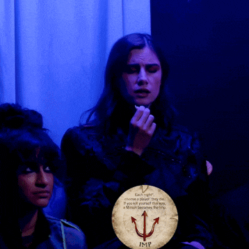 a woman in a dark room with a sign that says imp on it