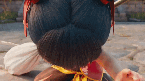 a close up of a person 's hair with a bun and a red bow
