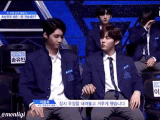 a man in a suit and tie is sitting next to another man in a suit