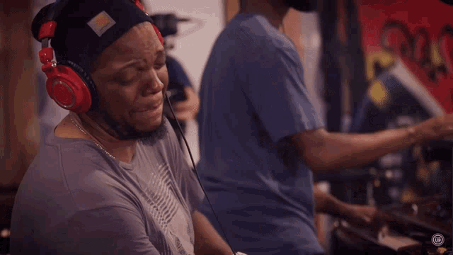 a man wearing headphones and a carhartt beanie looks down