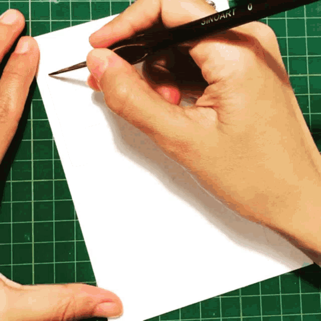 a person is writing on a piece of paper with a jinxuan brush in their hand
