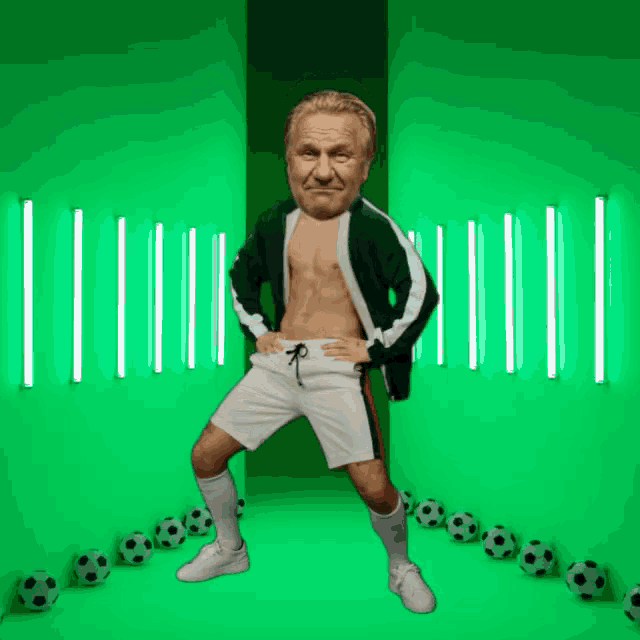 a man without a shirt is standing in front of a green wall