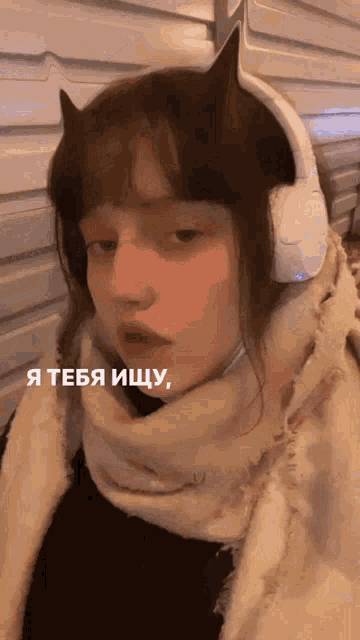 a girl wearing headphones and a scarf says " i teba iщу "