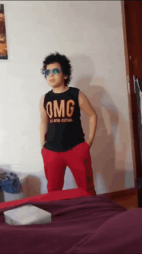 a young boy wearing sunglasses and a black shirt that says omg