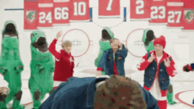 a group of kids dressed in dinosaur costumes are dancing on a ice rink