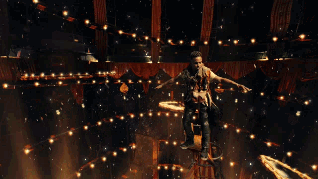a man with a crown on his head is standing in a dark room surrounded by lights