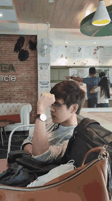 a man sits in a chair in front of a sign that says circle