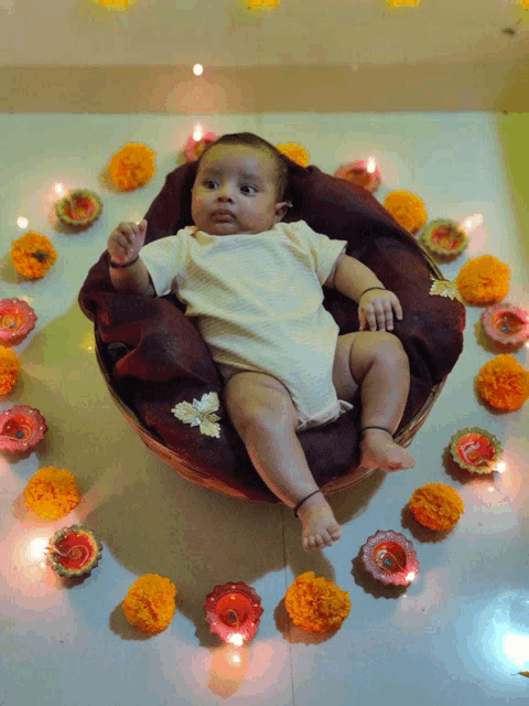 a baby is laying in a basket surrounded by candles and flowers