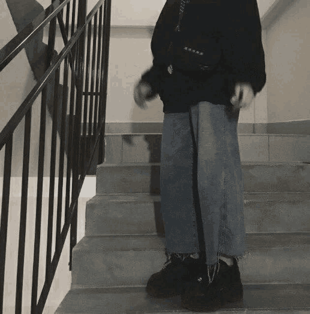 a person is standing on a set of stairs holding a cane .
