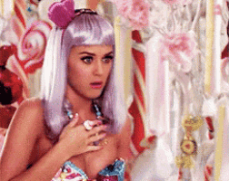 a woman wearing a purple wig and a pink flower on her head