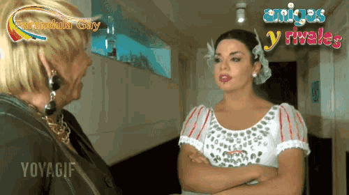a woman in a white dress is talking to another woman with the words amigos y rivales behind them