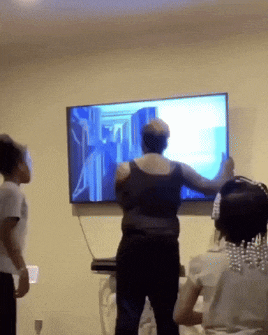 a woman stands in front of a flat screen tv