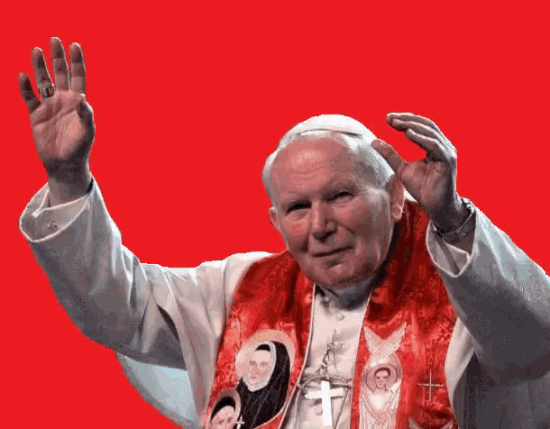 a man in a white robe with a red scarf around his neck waves