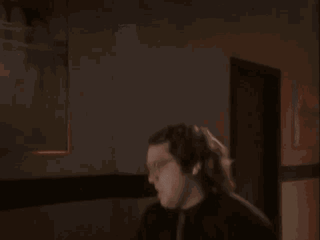 a blurry picture of a person in a dark room with a bottle of blood on their face .