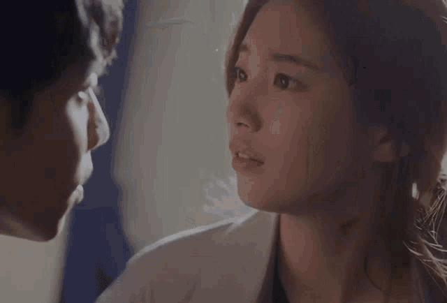 a man and a woman are looking at each other in a close up