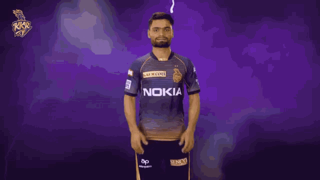 a man in a nokia shirt stands in front of a dark background