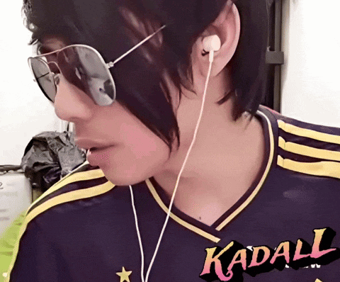 a person wearing sunglasses and ear buds with a shirt that says kadall