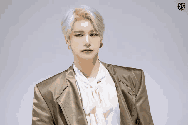 a man with blonde hair is wearing a gold jacket