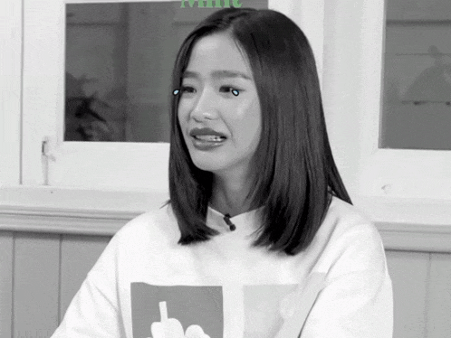 a black and white photo of a woman wearing a white sweater with a middle finger on it