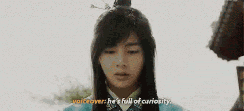 a young man in a traditional costume is talking to another person .