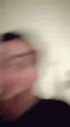 a blurry picture of a man 's face with glasses