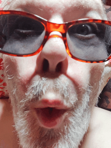 a man with a beard is wearing sunglasses and making a face