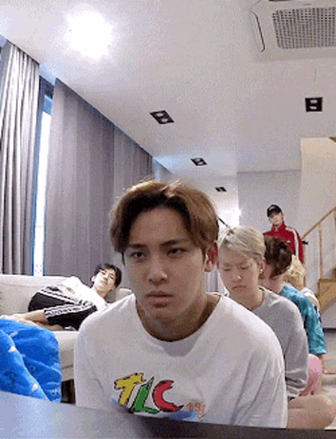 a young man wearing a tic t-shirt looks at the camera