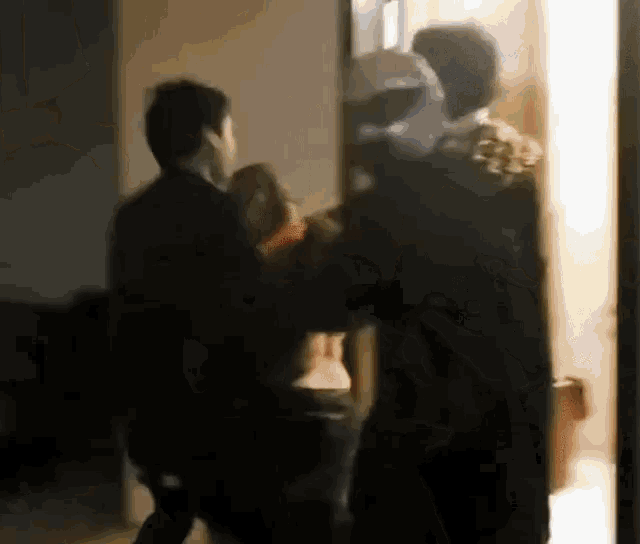 a group of people standing next to each other in a room .