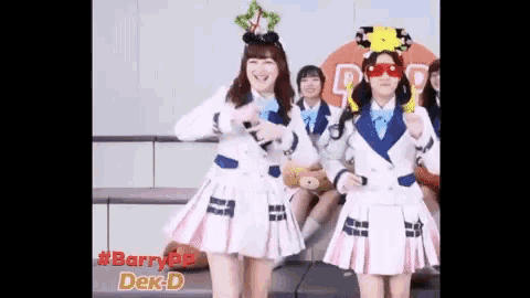 a group of girls in school uniforms are dancing in front of a sign that says dek-d