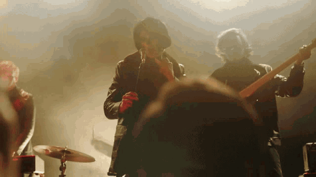 a man singing into a microphone while a man plays a guitar