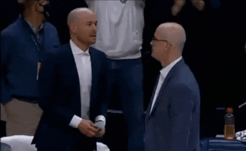 a group of men in suits are shaking hands .