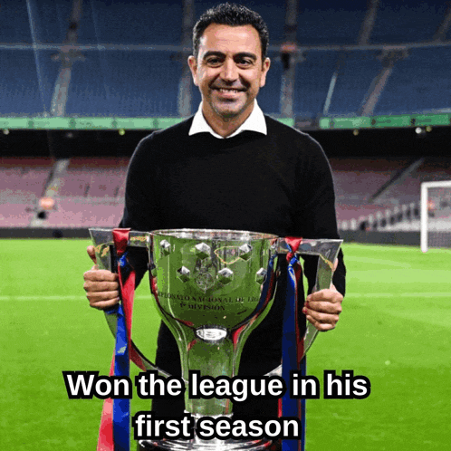 a man holding a trophy that says ' won the league in his first season '
