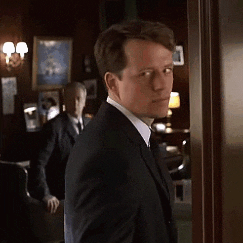 a man in a suit and tie is standing in front of a door .