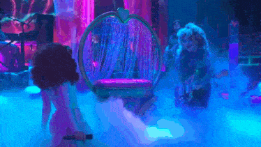 a woman is singing into a microphone in front of a chair with a heart on it