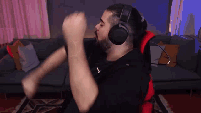 a man wearing headphones and a black shirt with the letter s on it