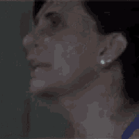 a woman is covering her face with her hand in a blurry photo