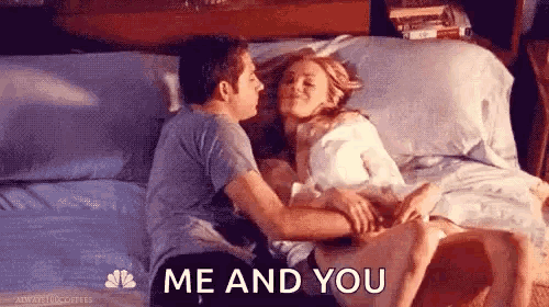 a man and a woman are laying on a bed and the man is kissing the woman .