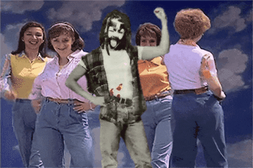 a group of women standing around a man with a beard