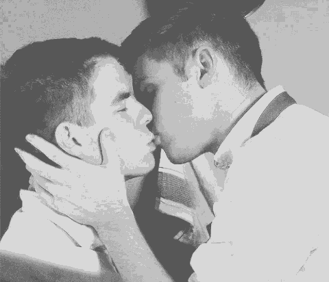 a couple of men kissing each other in a black and white photo