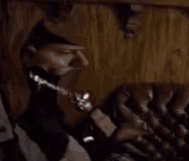 a close up of a puppet sitting in a chair with a chain around his neck .