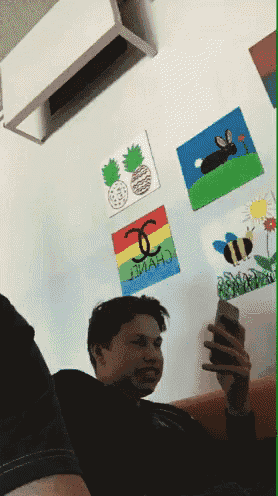 a man taking a picture of himself in front of a wall with chanel stickers on it
