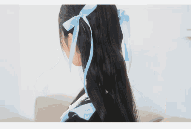 a woman with long black hair wearing a choker and a blue bow in her hair