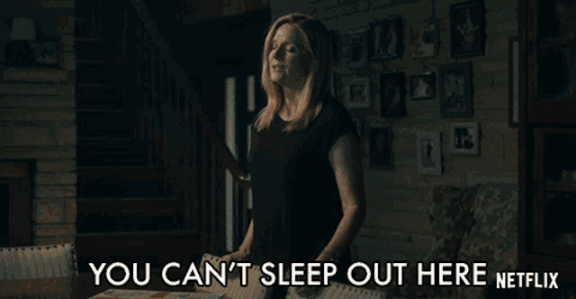 a woman is standing in a living room with the words you can 't sleep out here netflix written below her