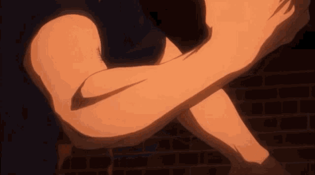 a close up of a person 's arm and leg in front of a brick wall