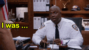 a police officer sits at a desk with a yellow sign that says " i was "
