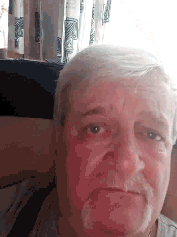 a close up of a man 's face with a white haired head