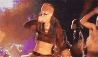 a woman in a crop top is singing into a microphone on a stage