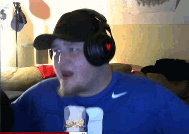 a man wearing headphones and a blue shirt that says nike on it