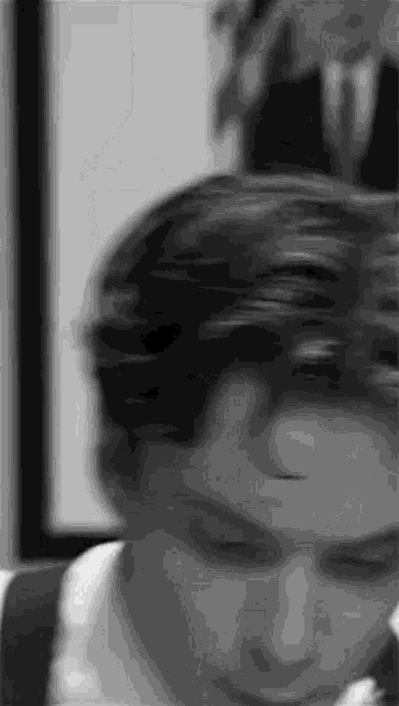 a black and white photo of a man 's face with a blurry background .