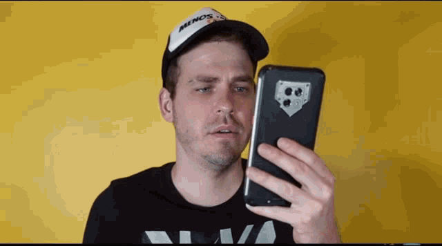 a man wearing a hat that says illinois looks at his phone